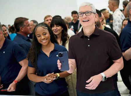 Apple CEO Tim Cook reacts as he holds the new iPhone 14 at an Apple event at their headquarters in Cupertino, California, U.S. September 7, 2022. REUTERS/Carlos Barria