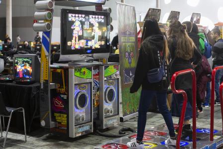 Two fairgoers play a dance machine