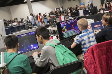 Young gamers testing classic consoles at the fair